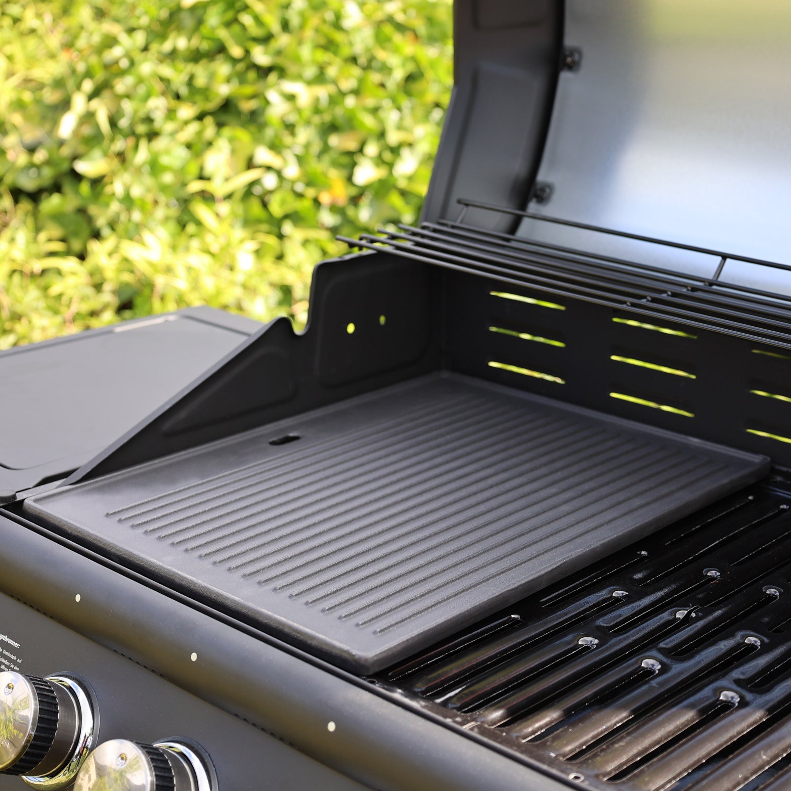 Nahaufnahme der TAINO PRO/RED Gusseisen-Grillplatte auf einem Gasgrill