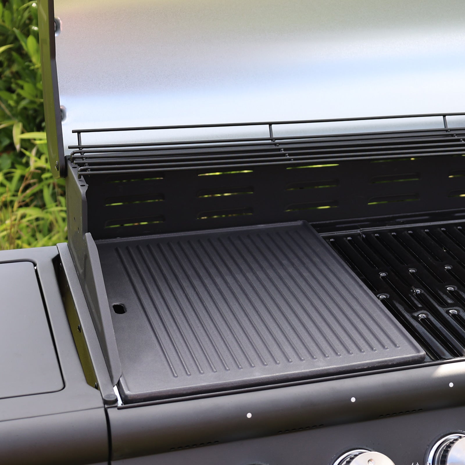 Die TAINO PRO/RED Gusseisen-Grillplatte liegt mit geriffelter Seite nach oben auf einem Gasgrill - 2