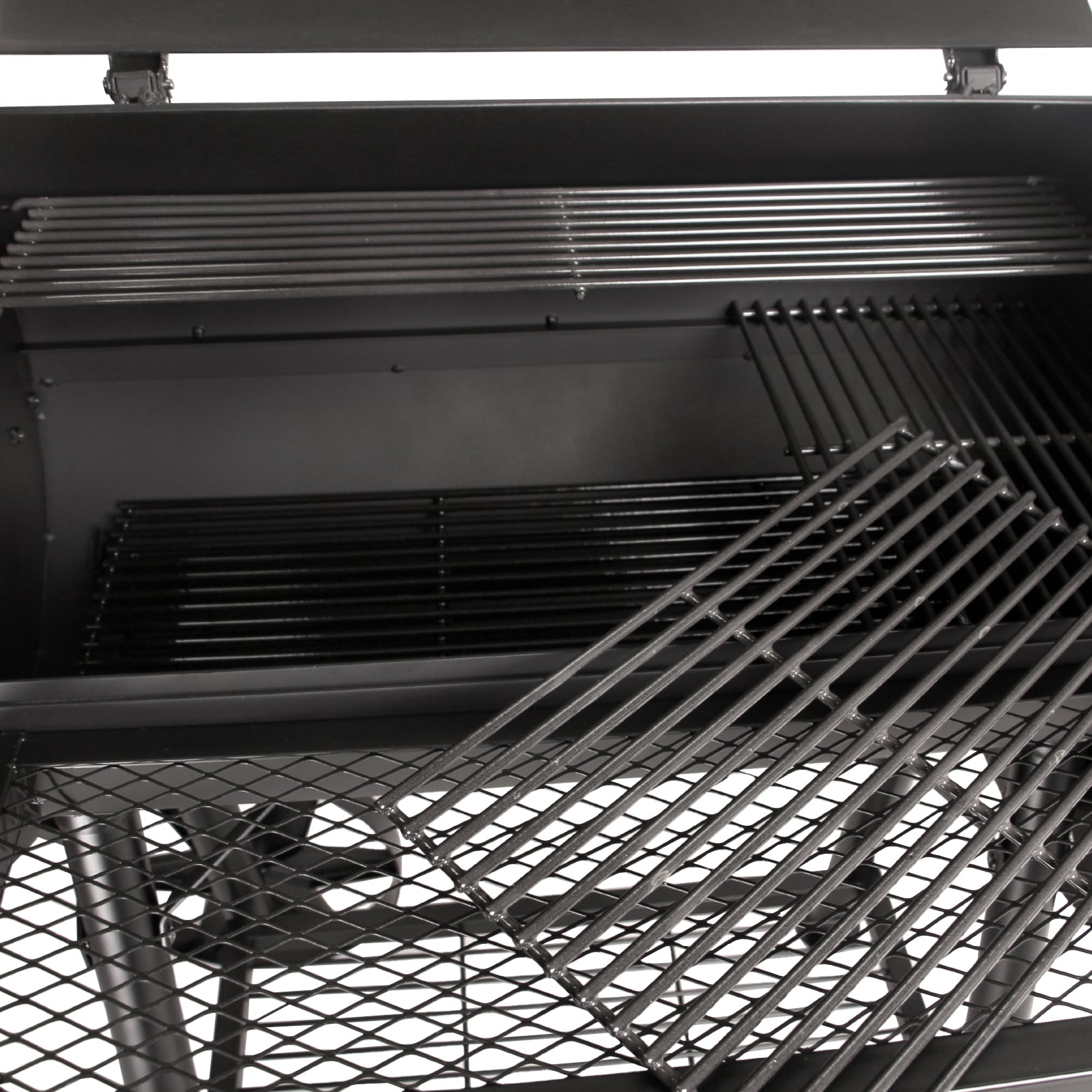 Nahaufnahme der Räucherkammer mit unten liegendem Kohlerost für normales Grillen und oben liegendem Warmhalterost