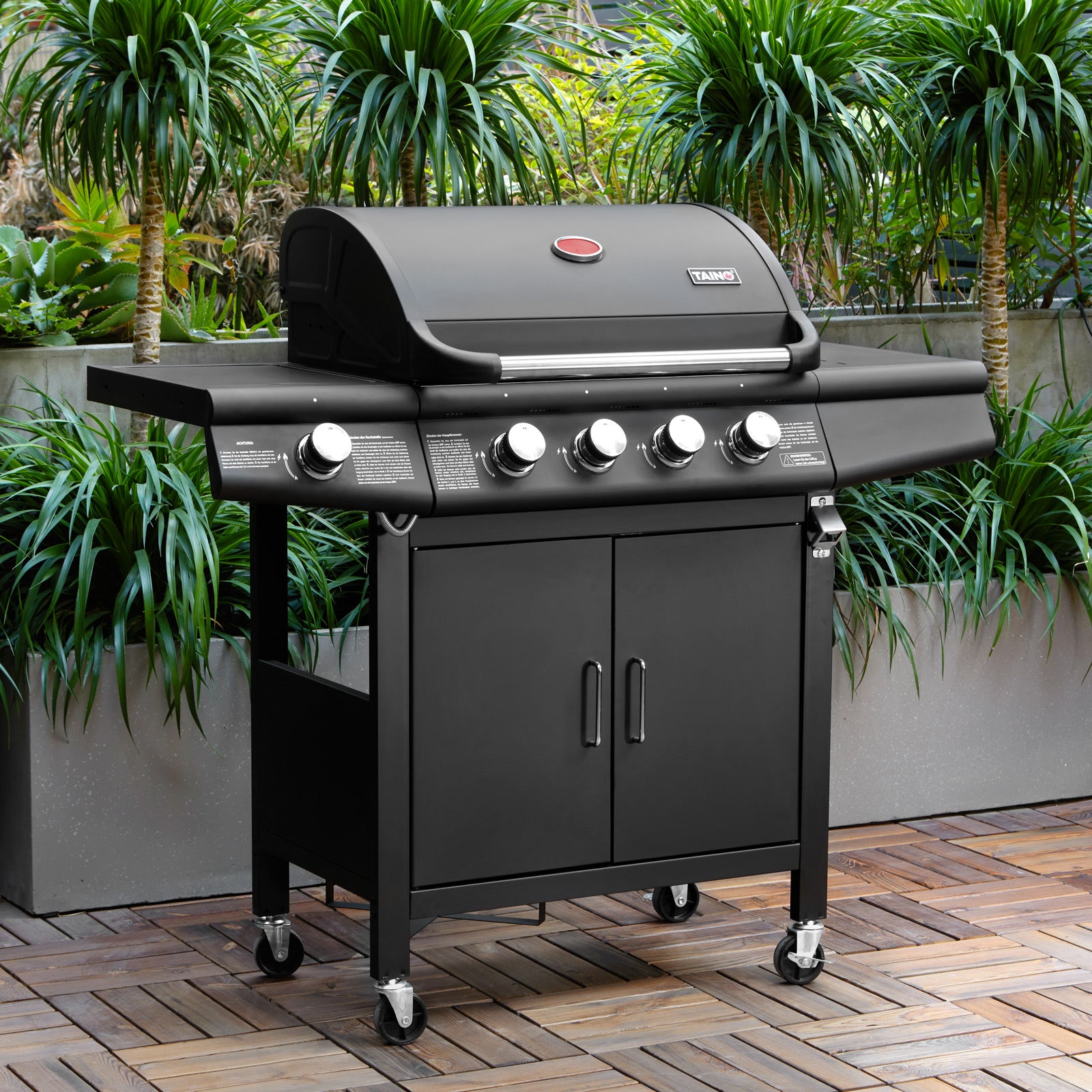 TAINO Red 4+1 - 4-Brenner Gasgrill mit Kochplatte - Ambientebild auf Terrasse