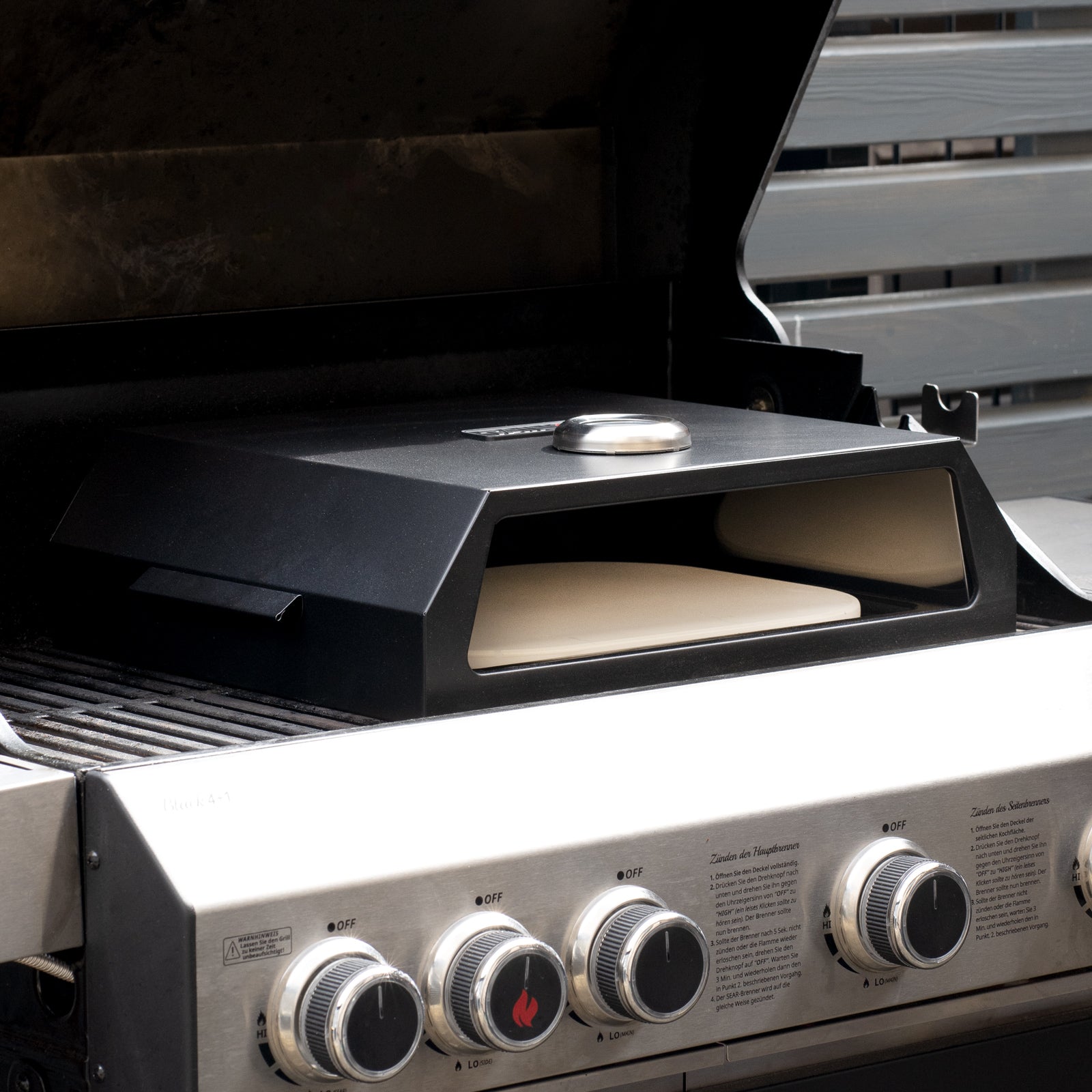 schwarze TAINO Pizzabox steht auf einem Gasgrill bereit